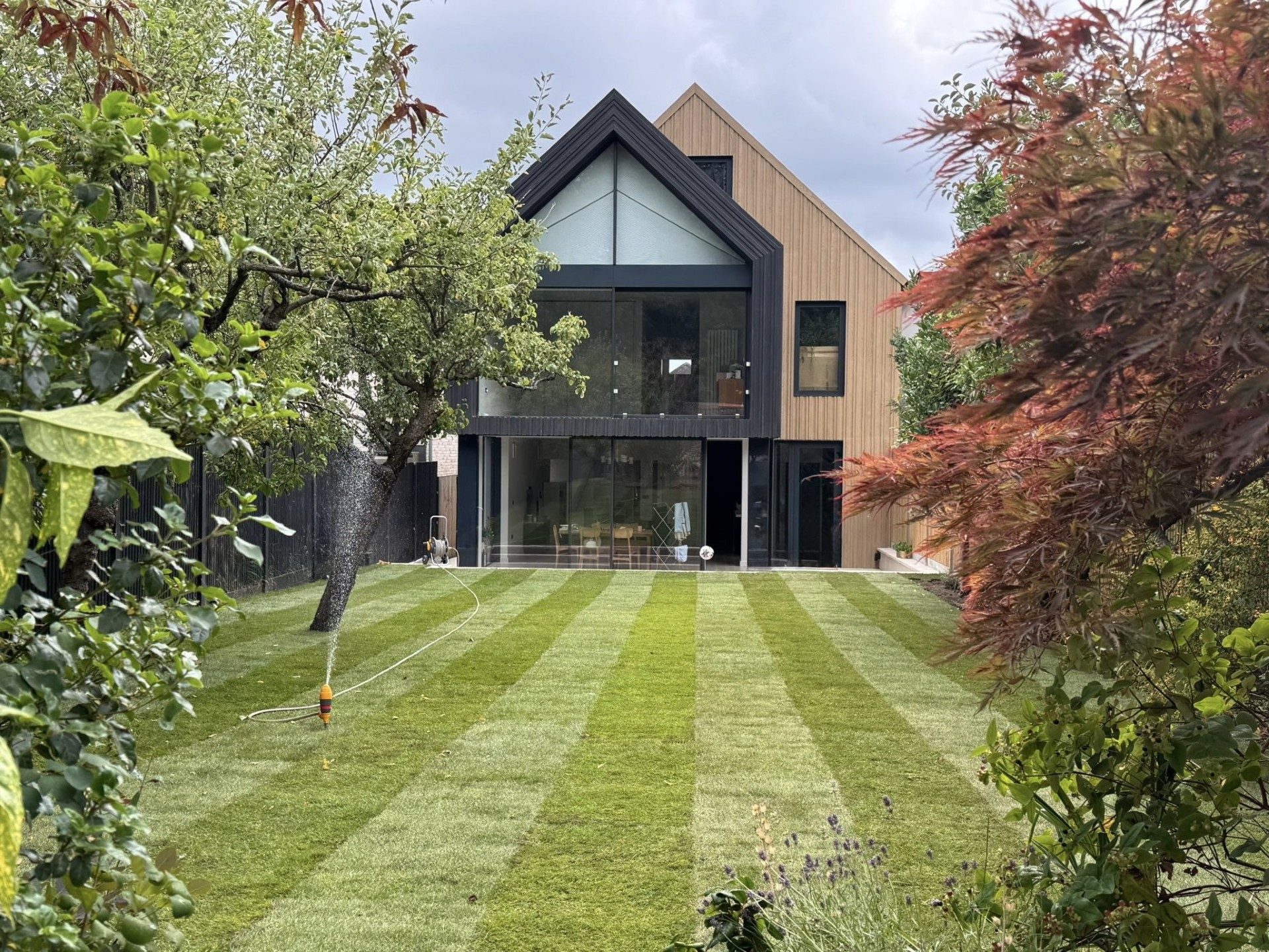 Modern rear extension with black timber cladding and a glazed gable end, completed by Studio & Build in South London